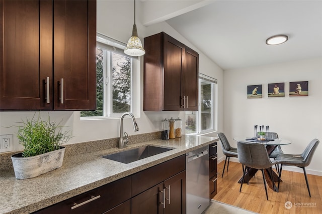 kitchen with sink, light stone counters, hanging light fixtures, light hardwood / wood-style flooring, and dishwasher