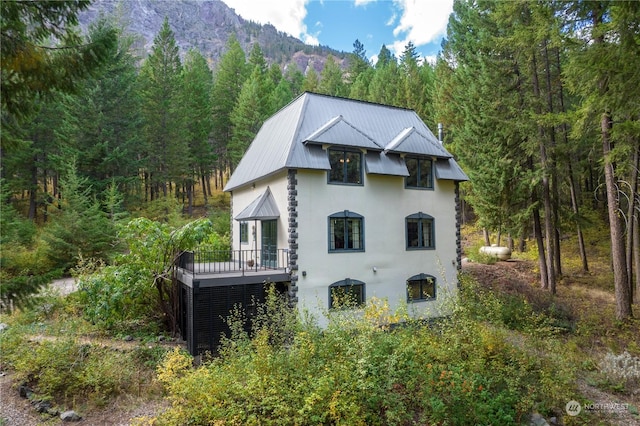 back of property with a deck with mountain view