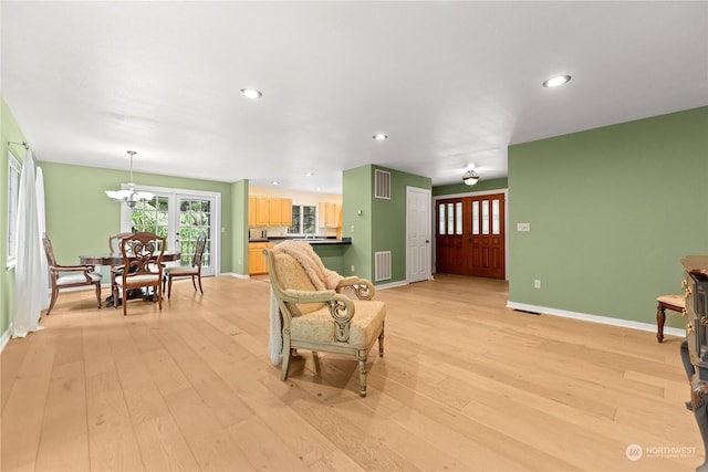 living room with a notable chandelier and light wood-type flooring