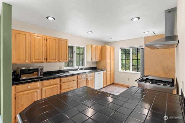 kitchen featuring sink, tile countertops, dishwasher, island exhaust hood, and a healthy amount of sunlight