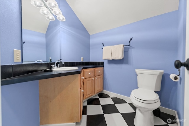 bathroom with vaulted ceiling, vanity, and toilet