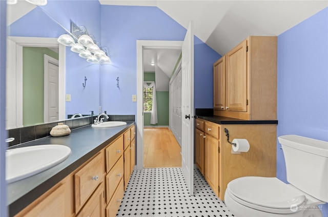 bathroom featuring vaulted ceiling, vanity, and toilet