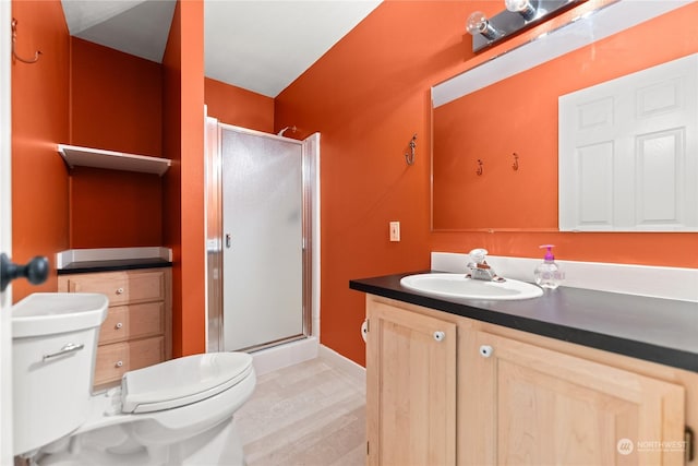 bathroom with vanity, hardwood / wood-style floors, a shower with door, and toilet