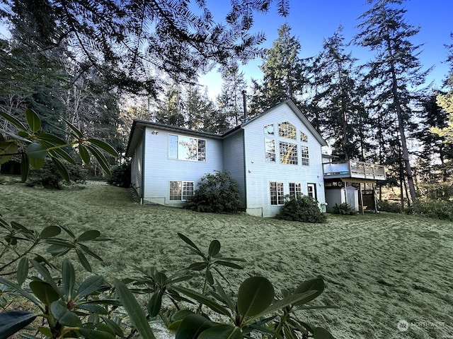 rear view of property featuring a yard and a deck