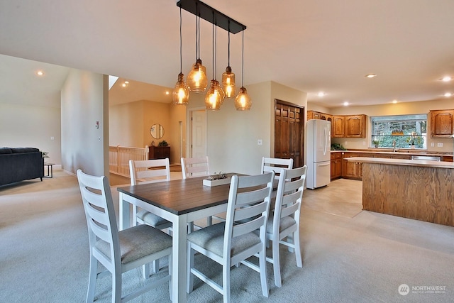 dining room featuring light carpet and sink