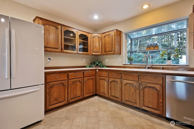 kitchen with white refrigerator, stainless steel dishwasher, and sink