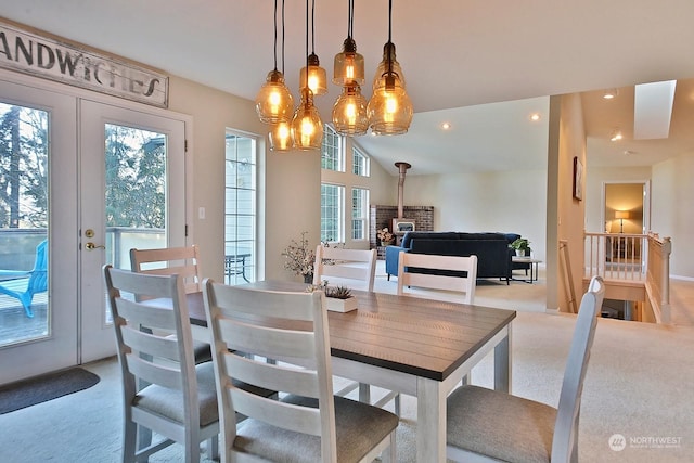 carpeted dining area featuring vaulted ceiling and french doors