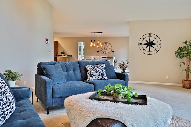 living room featuring light carpet and an inviting chandelier