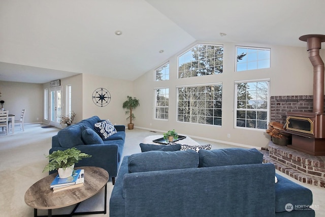 carpeted living room featuring a wood stove and high vaulted ceiling