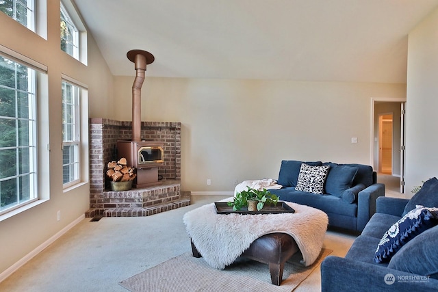 carpeted living room featuring a wood stove and high vaulted ceiling