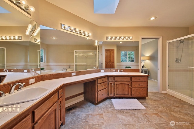 bathroom with vanity, a skylight, and a shower with shower door