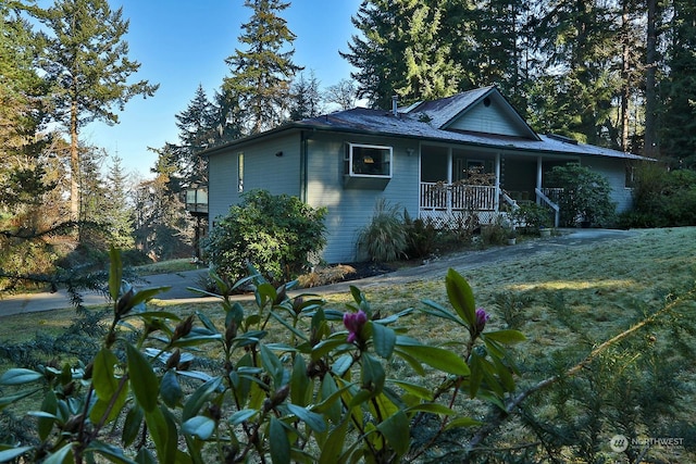 view of property exterior with a lawn and a porch