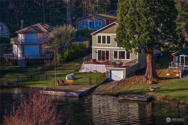 exterior space featuring a deck with water view and a lawn