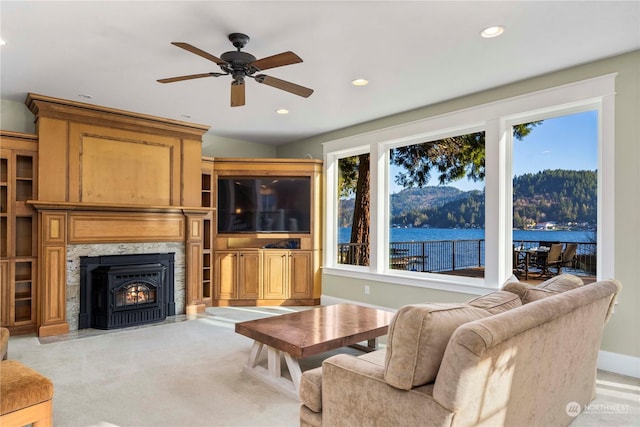 living room with ceiling fan, a fireplace, and light carpet