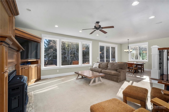 living room with ceiling fan with notable chandelier and light carpet