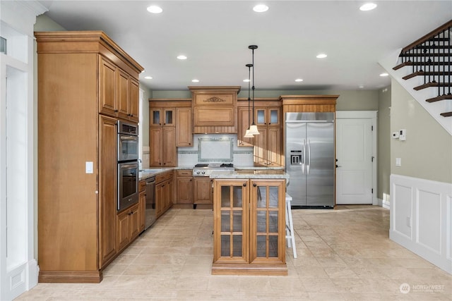 kitchen with a kitchen bar, a kitchen island, pendant lighting, stainless steel appliances, and backsplash