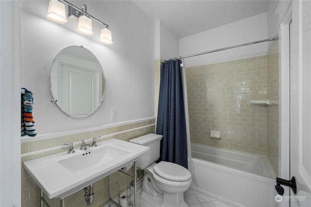 full bathroom featuring sink, shower / bath combo, tile walls, tile patterned flooring, and toilet