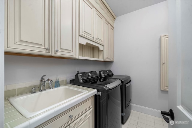 laundry room featuring cabinets, independent washer and dryer, and sink