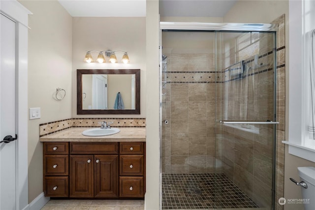 bathroom featuring tasteful backsplash, vanity, toilet, and an enclosed shower