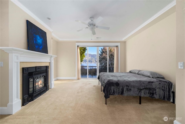 carpeted bedroom featuring crown molding, ceiling fan, access to exterior, and a tiled fireplace