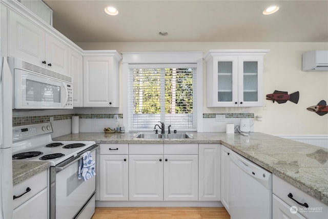 kitchen with white cabinetry, sink, and white appliances