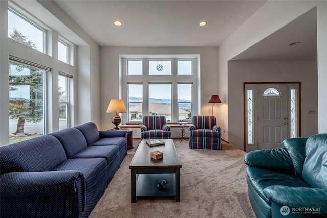 carpeted living area with recessed lighting, a mountain view, and a healthy amount of sunlight