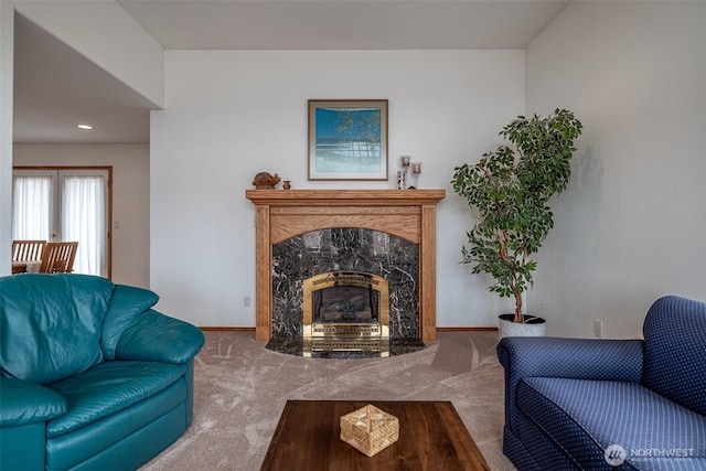 living area featuring a premium fireplace, baseboards, and carpet floors