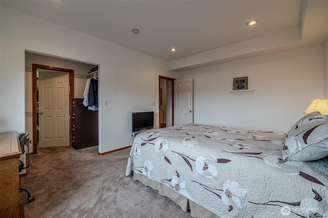 carpeted bedroom featuring a spacious closet, recessed lighting, and baseboards