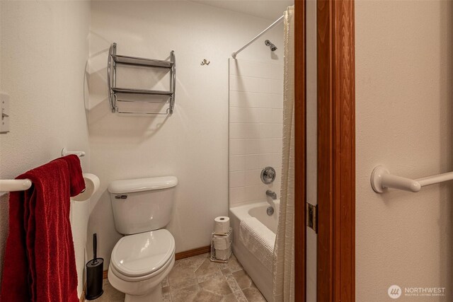 bathroom with toilet, baseboards, and shower / bath combination