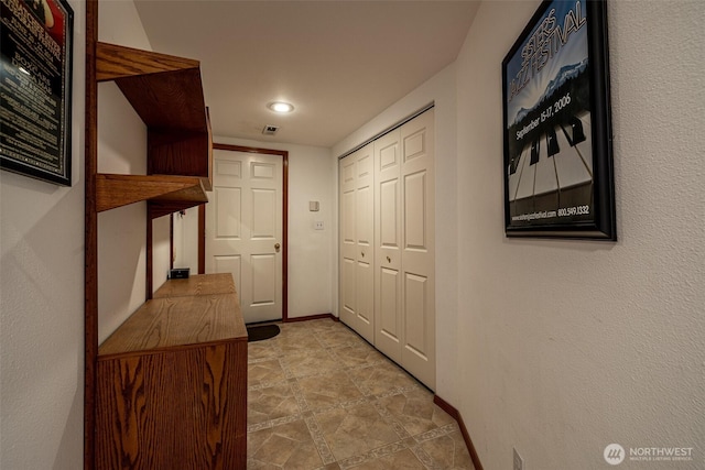 hallway with visible vents and baseboards