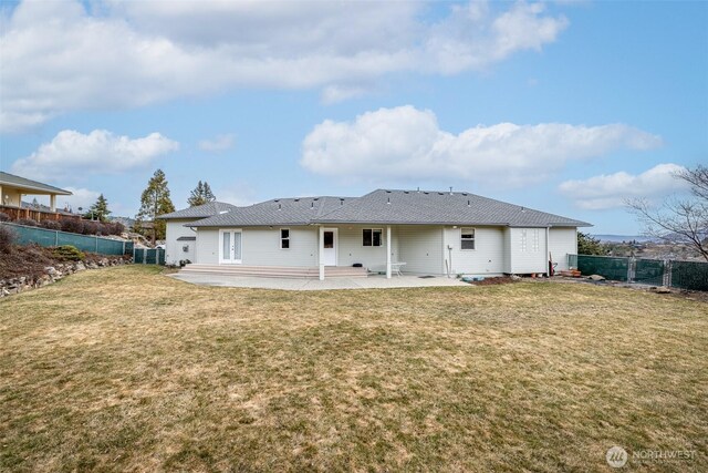 back of property with a yard, a patio, and fence