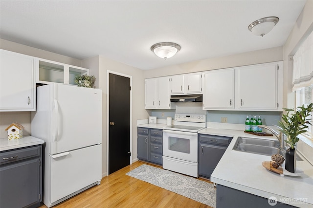 kitchen with under cabinet range hood, white appliances, a sink, white cabinets, and light countertops