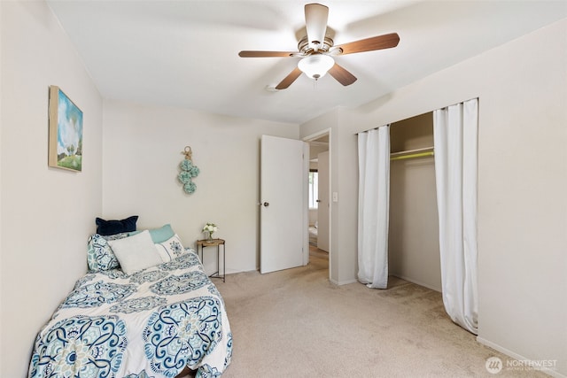 bedroom with light carpet, ceiling fan, and a closet