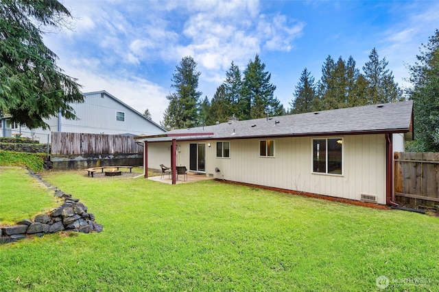 rear view of property featuring a yard, an outdoor fire pit, crawl space, a patio area, and fence