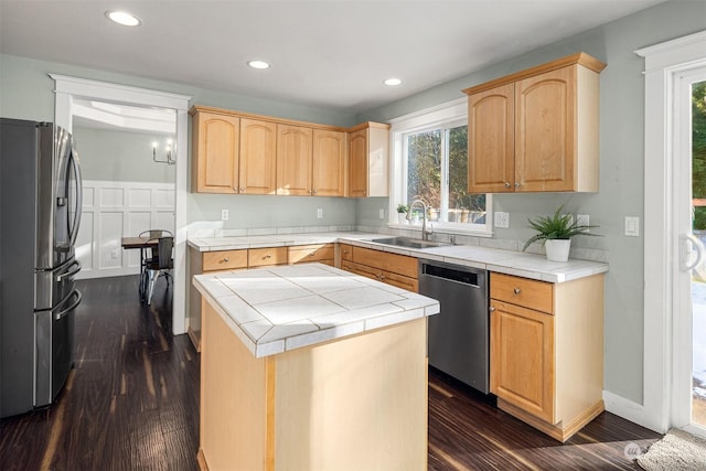 kitchen featuring sink, light brown cabinets, tile counters, a kitchen island, and stainless steel appliances