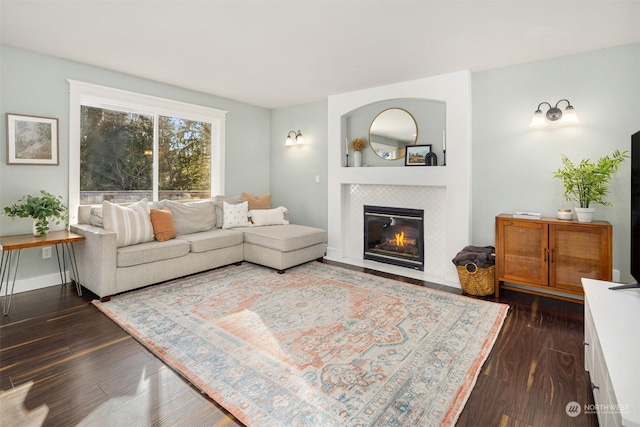 living room featuring a tiled fireplace and dark hardwood / wood-style floors