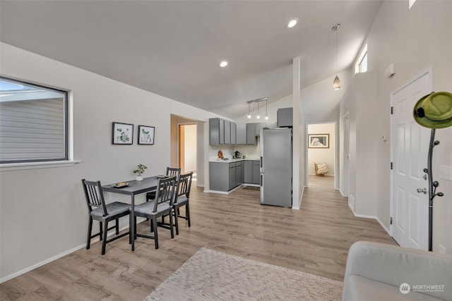 dining space with lofted ceiling and light hardwood / wood-style floors