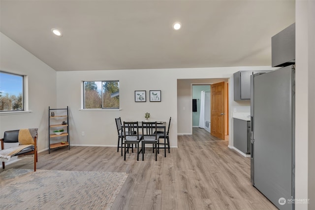 dining room featuring vaulted ceiling and light wood-type flooring