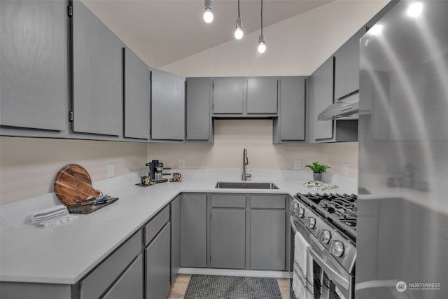 kitchen with sink, wall chimney range hood, gray cabinets, appliances with stainless steel finishes, and decorative light fixtures