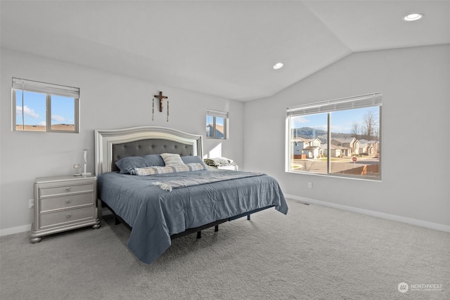 bedroom with multiple windows, lofted ceiling, and carpet