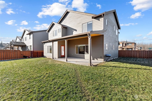 back of house featuring a lawn and a patio area