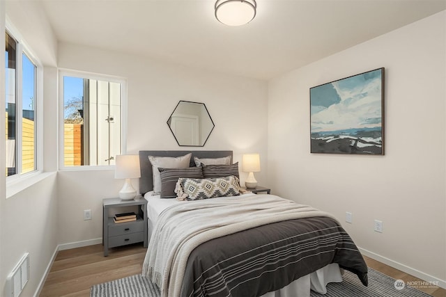 bedroom featuring multiple windows and light wood-type flooring