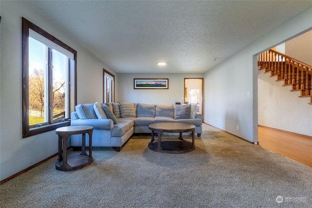 carpeted living room featuring a textured ceiling