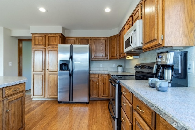 kitchen featuring light hardwood / wood-style flooring and appliances with stainless steel finishes