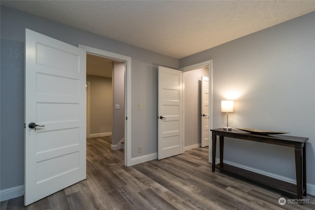 bedroom with dark hardwood / wood-style floors and a textured ceiling