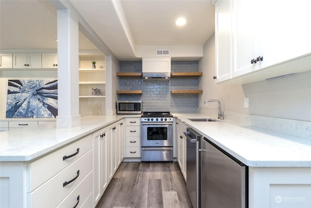 kitchen featuring sink, hardwood / wood-style flooring, stainless steel appliances, light stone countertops, and white cabinets