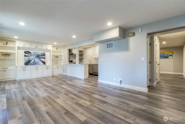 unfurnished living room featuring a textured ceiling and light hardwood / wood-style flooring