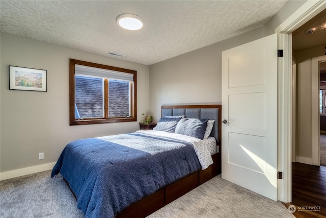 bedroom with carpet floors and a textured ceiling