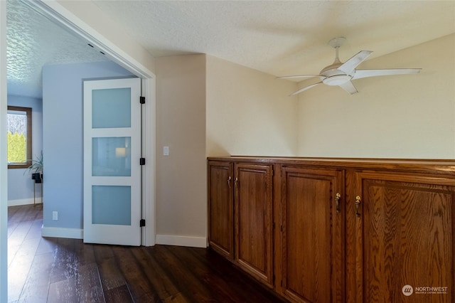 hallway with dark hardwood / wood-style floors and a textured ceiling