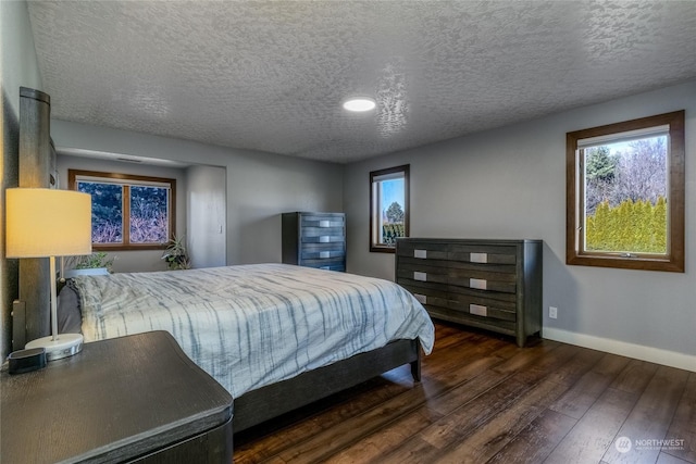 bedroom featuring dark hardwood / wood-style floors and a textured ceiling